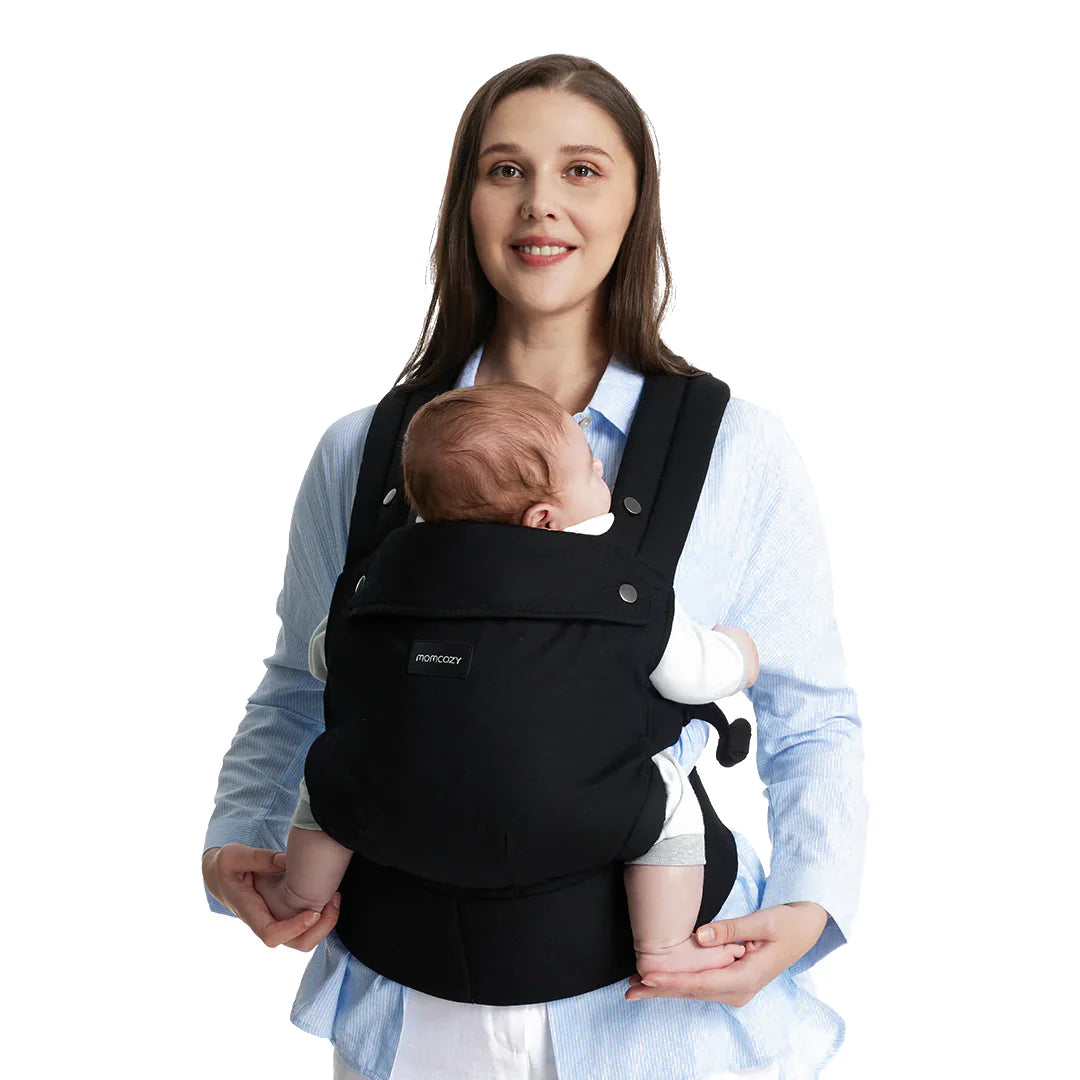Mamá llevando a su bebé en el portabebé Momcozy, mostrando comodidad y estilo.