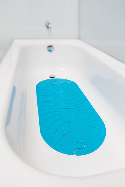 Boon Ripple Mat de Tina Antideslizante Calipso en la tina, proporcionando estabilidad durante el baño del bebé.